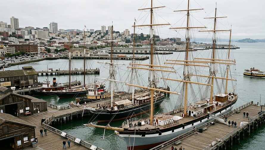 Historic wooden sailing ships docked at the waterfront of a renowned maritime museum.