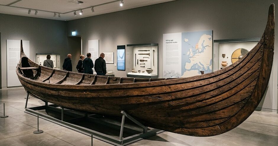 Maritime Museums Maritime Museums: A beautifully preserved wooden Viking longship on display inside a maritime museum exhibit.