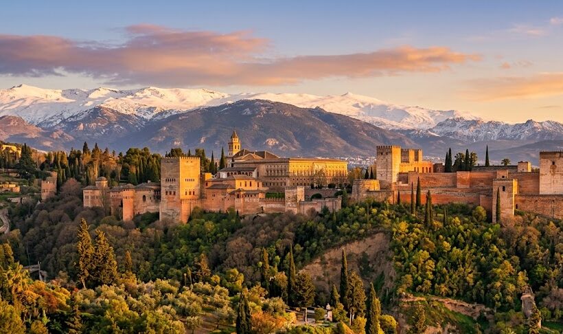 The historic Alhambra palace with the snowy Sierra Nevada mountains in the background in Granada, Spain.